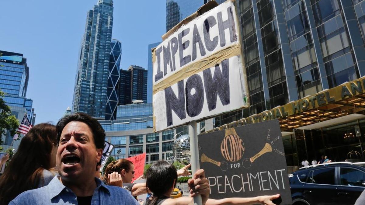 Protesters rally outside a Trump hotel to call for the impeachment of President Trump, Sunday July 2, 2017, in New York.