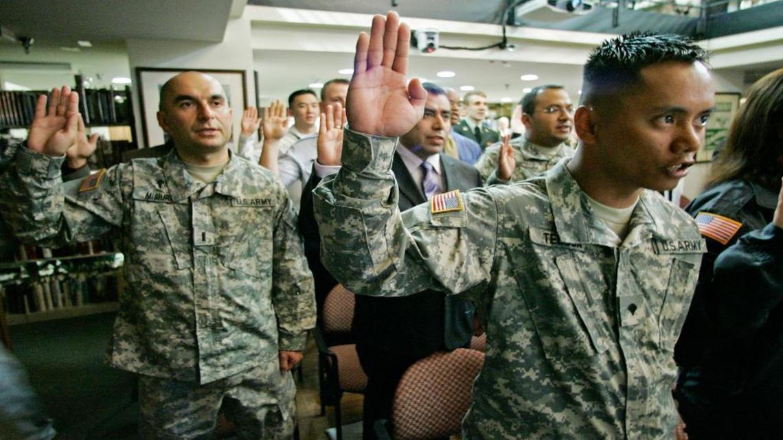 U.S. Army Reserve Lt. Krzysztof Misiura, formerly of Poland, left, and USAR Specialist Christian Joy Tecson, formerly of the Philippines, right, take the Oath of Allegiance along with 28 other members of the U. S. Armed Forces Friday, May, 23, 2008 as they become U.S. Citizens during a ceremony at the Pritzker Military Library in Chicago.