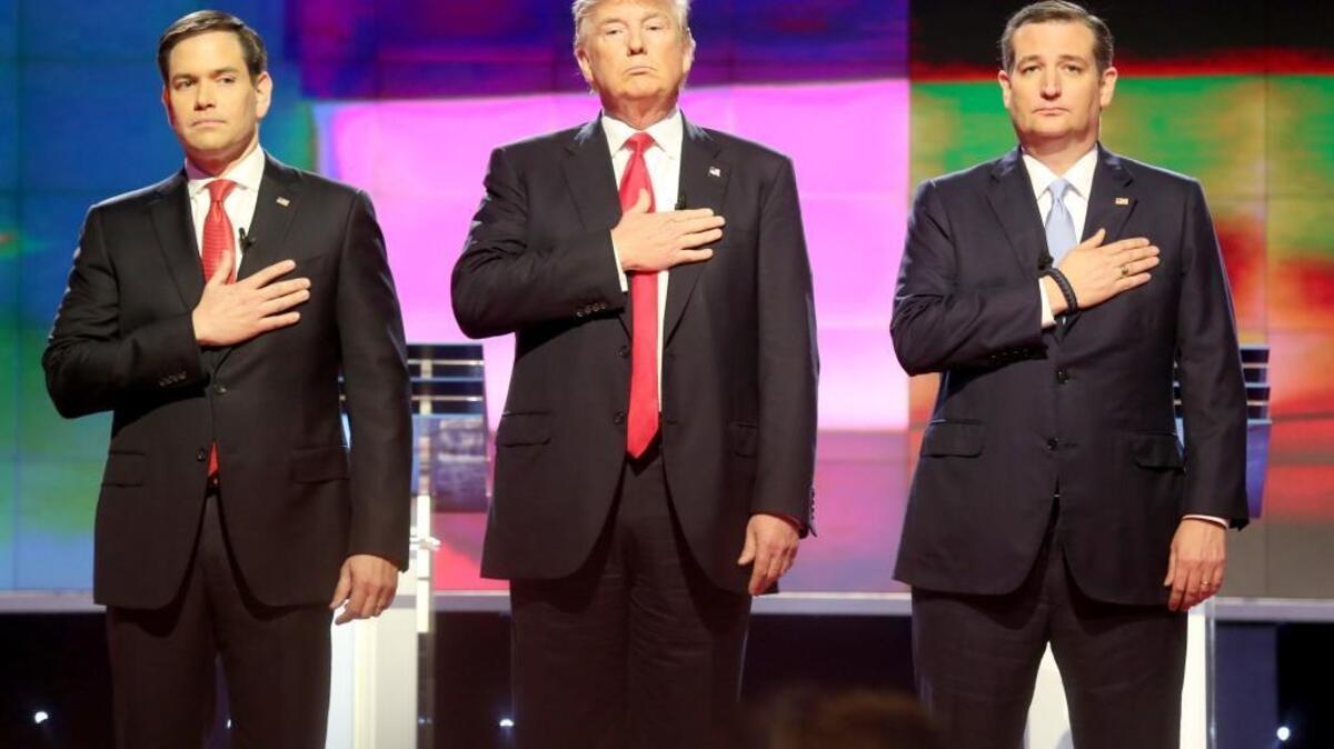 FILE - Republican presidential candidates, Sen. Marco Rubio, R-Fla, from left, Donald Trump and Sen. Ted Cruz, R-Texas stand up for the national anthem during a primary debate at the University of Miami in Coral Gables, a suburb of Miami on March 10, 2016.