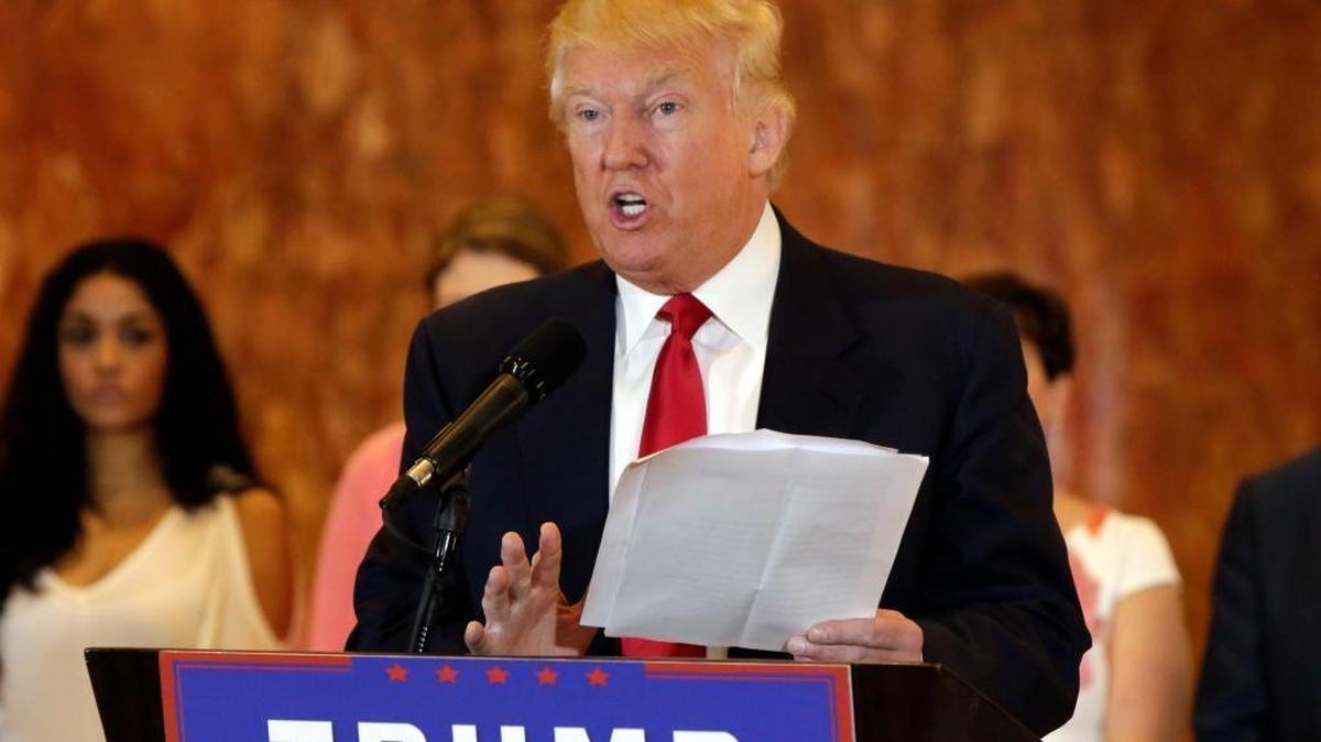 Republican presidential candidate Donald Trump reads from a list of donations to veterans groups during a news conference in New York, Tuesday, May 31, 2016.