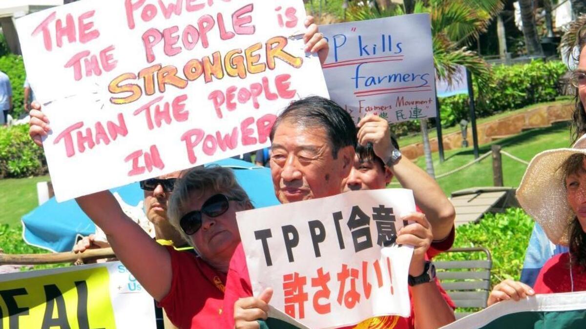Former Japanese Agriculture Minister Masahiko Yamada, center, and other demonstrators protest outside the Westin Maui resort in Lahaina, Hawaii, on July 29, 2015, as ministers from Pacific Rim nations gathered to negotiate the Trans-Pacific Partnership. President Donald Trump on Monday withdrew the U.S. from the 12-nation pact, which had been a top priority for former President Barack Obama.