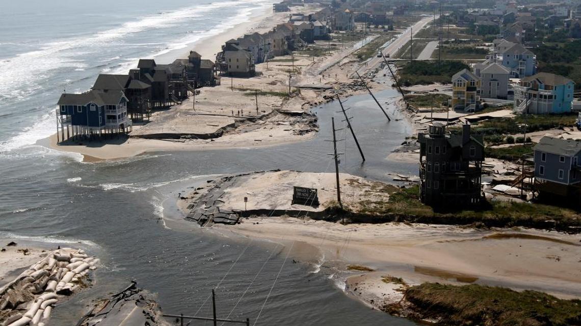 Floodwaters cut a roadway on Hatteras Island, N.C., in five places on Aug. 28, 2011, after the area took a wallop from Hurricane Irene. Flooding is expected to worsen due to a rise in sea levels that scientists blame on global warming.