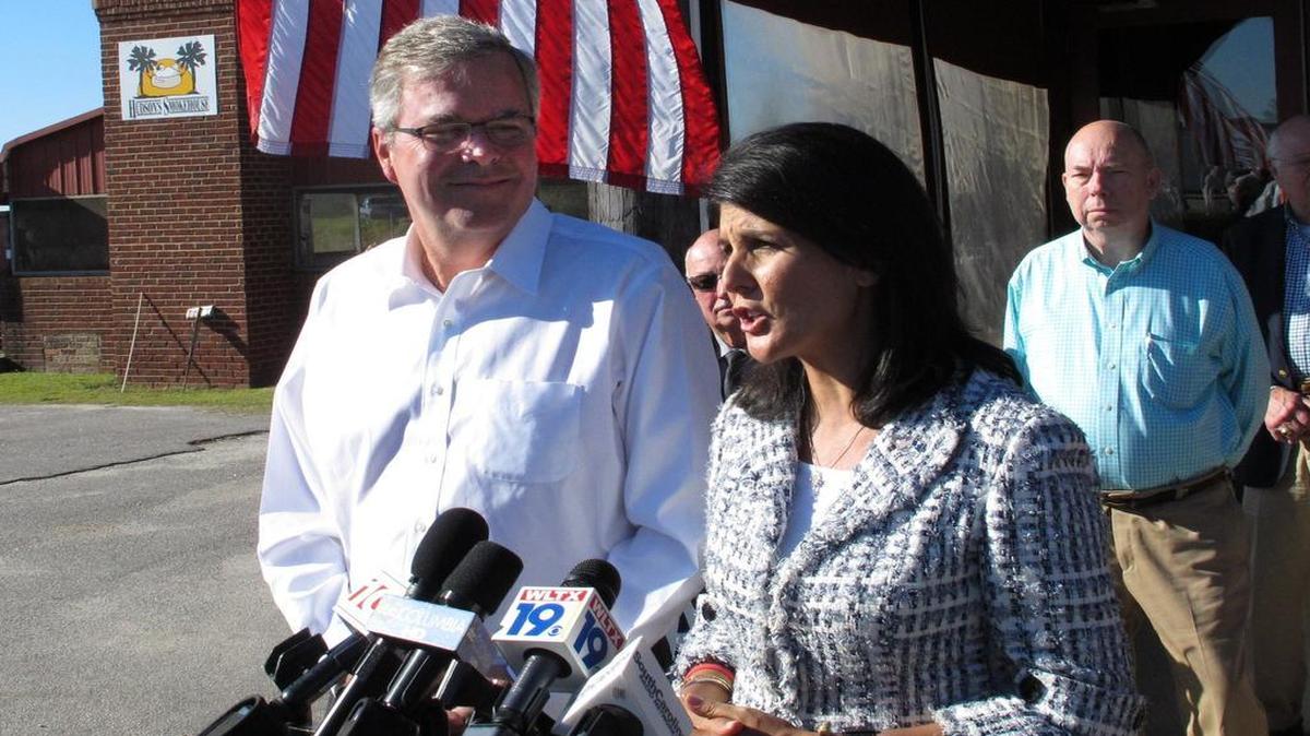 S.C. Gov. Nikki Haley speaks to reporters as former Florida Gov. Jeb Bush listens after a Haley campaign event in 2014, in Lexington, S.C.