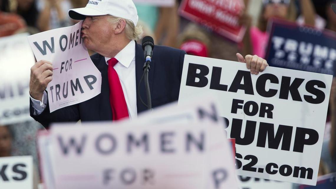 At a Florida rally on Wednesday, Republican presidential candidate Donald Trump kisses a "Women for Trump" sign.