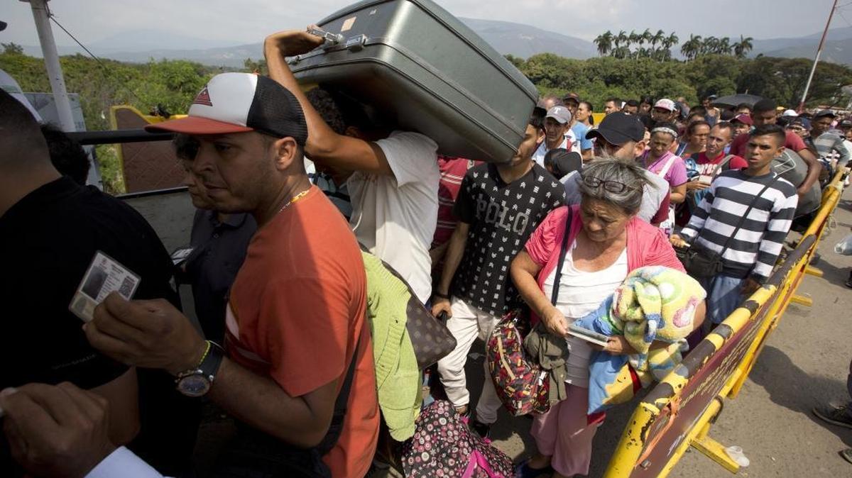 In this Feb. 21, 2018 photo, Venezuelans cross the International Simon Bolivar bridge into the Colombia. As Venezuela's economic crisis worsens, rising numbers are fleeing in a burgeoning refugee crisis that could soon match the flight of Syrians from the war-torn Middle East.