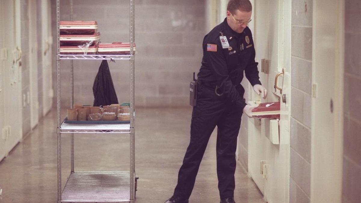 Lt. Fred Wilson collects food trays from inmates at the Eastern Kentucky Correctional Complex in West Liberty, Ky., on Jan. 21, 1999.