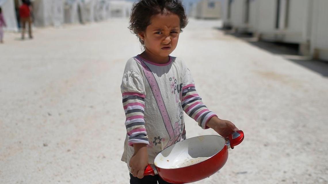 In this June 19, 2015 file photo, a Syrian refugee child walks at a refugee camp in Suruc, on the Turkey-Syria border. Some 28 million children around the globe have been driven from their homes by violent conflict, with nearly as many abandoning their homes in search of a better life, according to a UNICEF report released Tuesday, Sept. 6, 2016. The report found that while children make up about a third of the world's population as of 2015, they accounted for nearly half of all refugees, with the number of child refugees having doubled in the last decade.