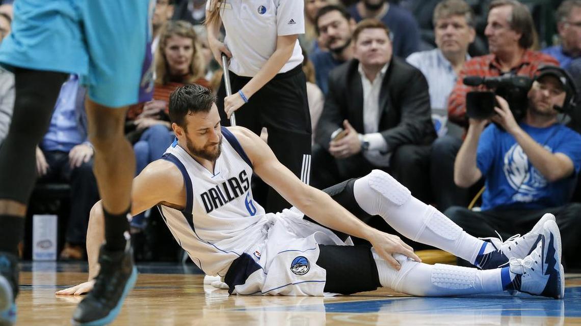 Dallas Mavericks center Andrew Bogut (6) of Australia reaches down to his right leg after suffering a knee injury in the first half of an NBA basketball game against the Charlotte Hornets on Monday, Dec. 5, 2016, in Dallas.