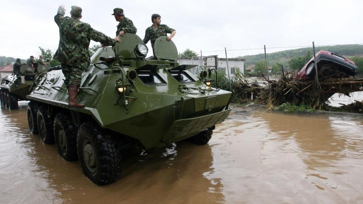 Bulgarian soldiers survey the area from atop a military vehicle during flooding in the town of Tzar Kaloyan, 260 kilometers (160 miles) east of the Bulgarian capital Sofia, Tuesday, Aug, 7, 2007. Torrential rain after weeks of drought caused severe flooding in northern Bulgaria, sweeping away cars, reducing dozens of homes to rubble and killing at least seven people.