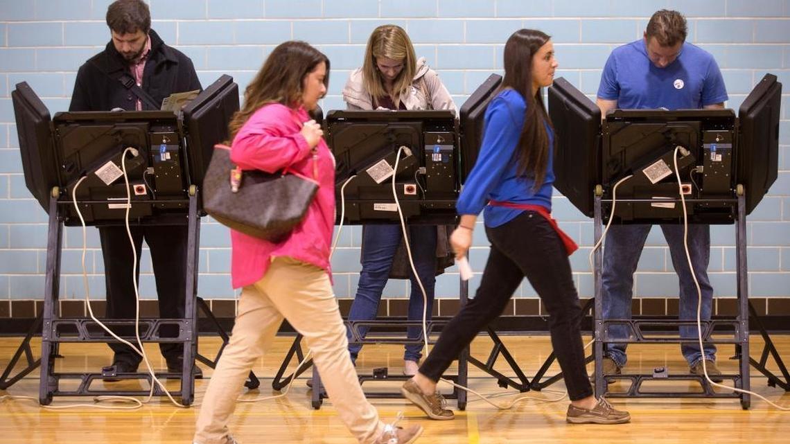 A poll worker leads a voter to an electronic voting machine on Election Day in Ohio last year. As this year’s presidential election approaches, election officials and computer security experts worry that many states still use older machines with outdated technology that could break down or be targeted by hackers, possibly compromising the results.