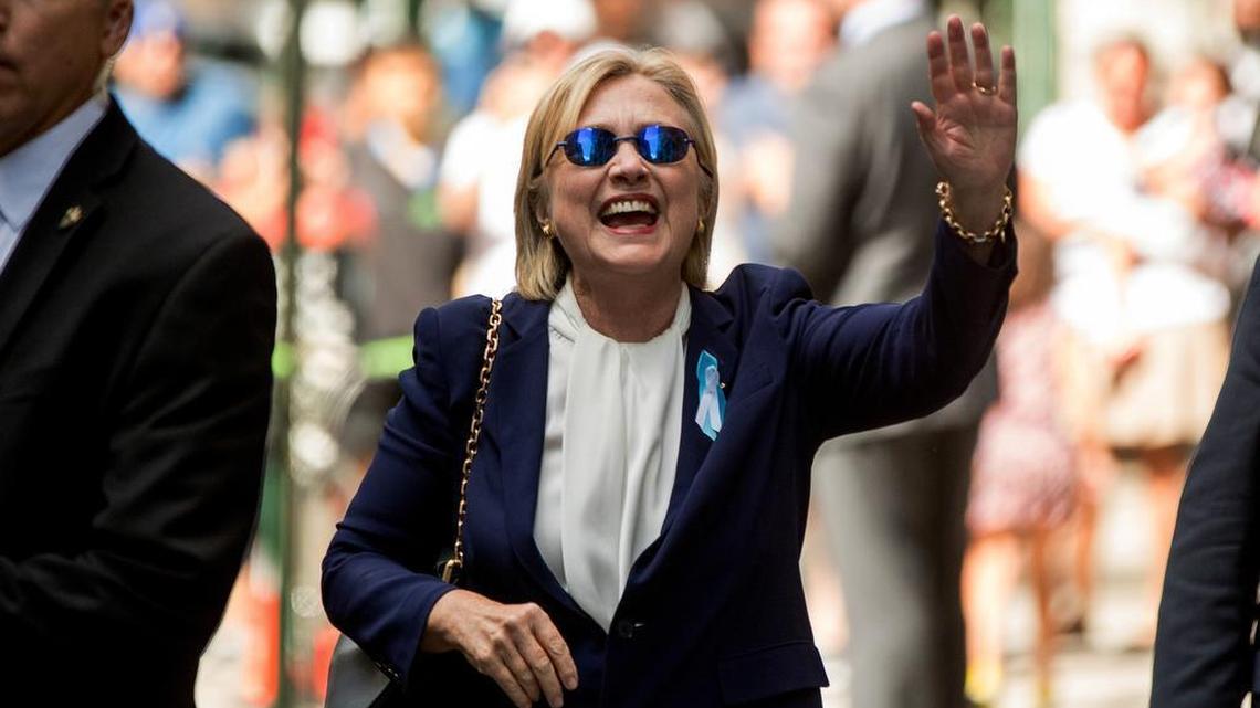 Democratic presidential candidate Hillary Clinton waves after leaving an apartment building Sunday in New York. Clinton's campaign said the Democratic presidential nominee left the 9/11 anniversary ceremony in New York early after feeling "overheated." On Wednesday, her doctor said Clinton was “healthy and fit” to be president.