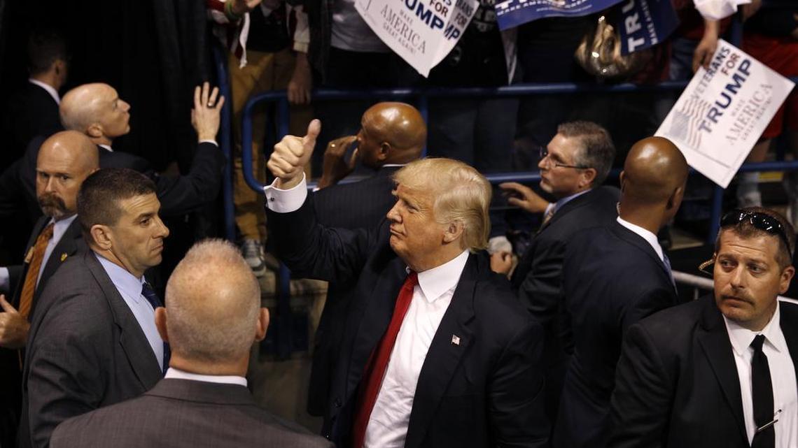 Security stands nearby as Republican presidential candidate, Donald Trump, center, gives a thumbs up to supporters after speaking at a campaign rally April 25, 2016, in Wilkes-Barre, Pa.