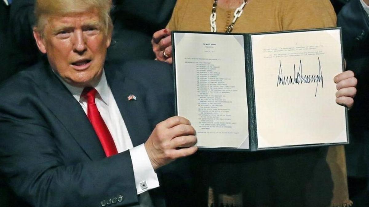 President Donald Trump signs a national security memorandum on strengthening U.S. policy toward Cuba during an appearance at the Manuel Artime Theater in Miami on June 16, 2017.