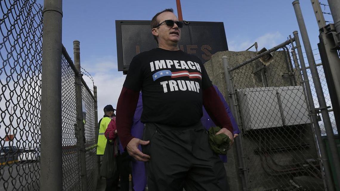 Pat Waters wears a shirt that reads Impeach Trump after he participated in Bridge Together Golden Gate, a demonstration and performance art piece against the inauguration of President Donald Trump, on the Golden Gate Bridge in San Francisco, Friday, Jan. 20, 2017.