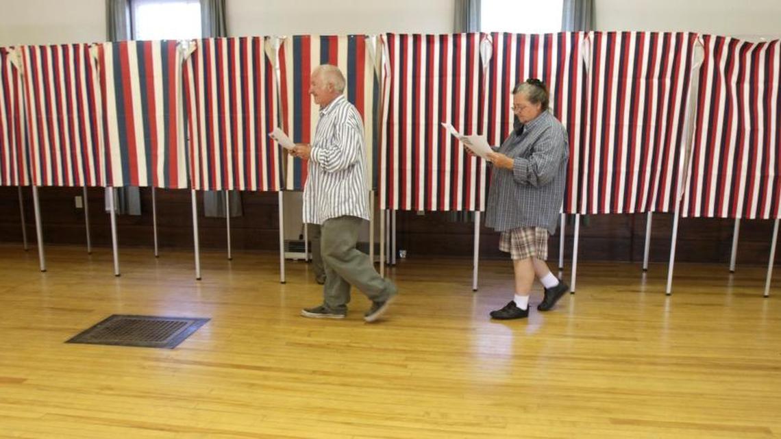 Larry and Jeri Kennison walk past voting booths after marking their ballots in Middlesex, Vt. on Aug. 24, 2010.