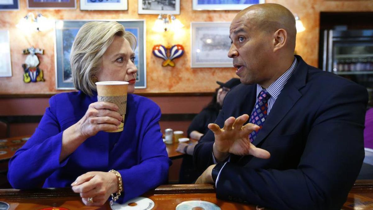 Democratic presidential candidate Hillary Clinton talks with Sen. Cory Booker, D-N.J., at Omar's Cafe while campaigning, June 1, 2016, in Newark, N.J.