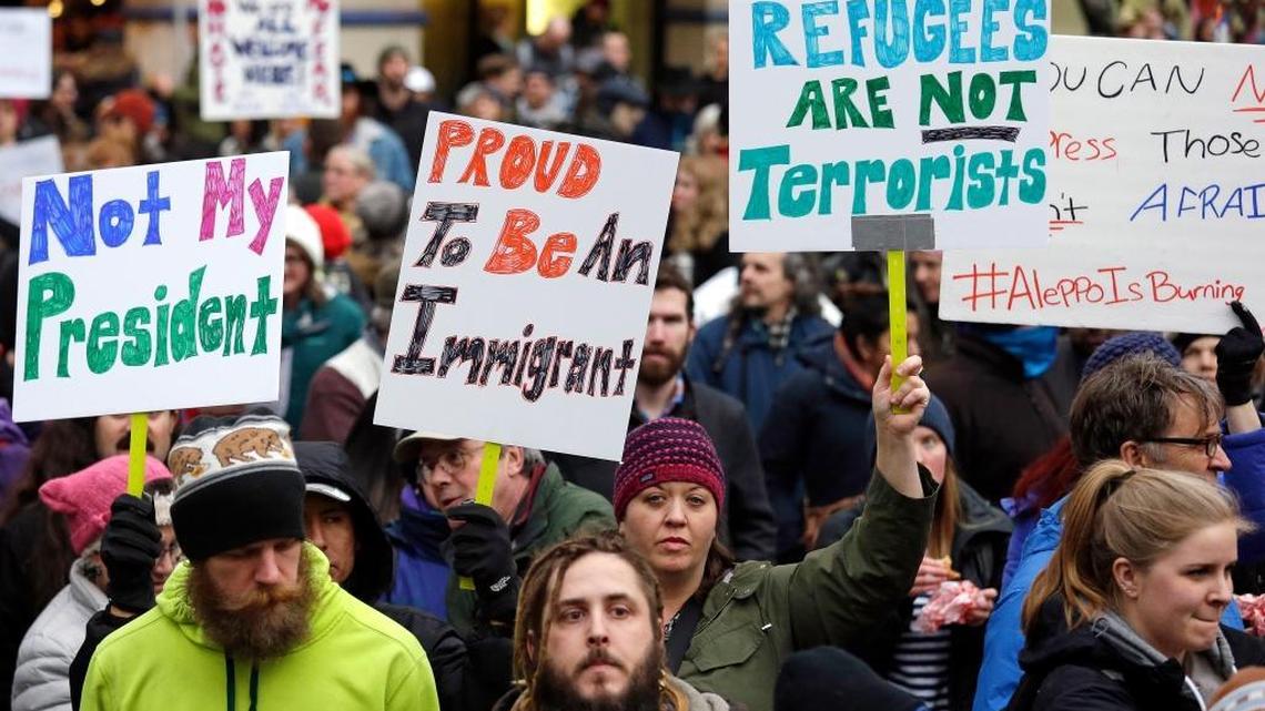 People begin to gather before a rally protesting President Donald Trump's travel ban on refugees and citizens of seven Muslim-majority nations, Sunday, Jan. 29, 2017, in Seattle.