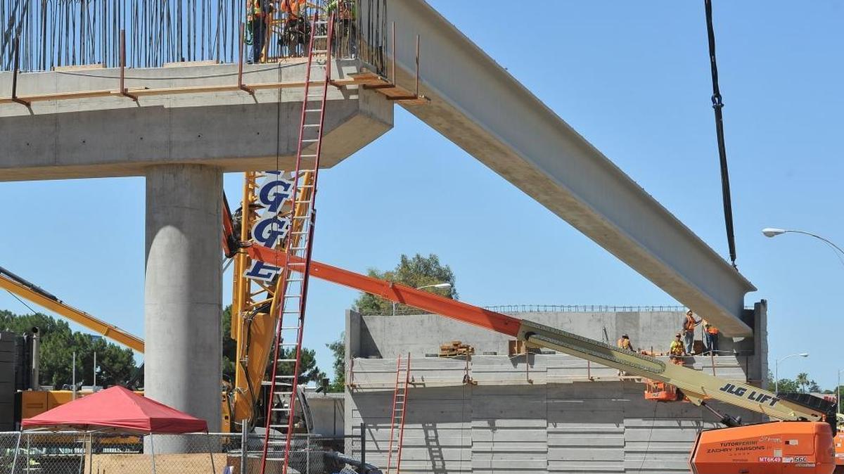 Workers fit a girder onto a support structure during construction by contractors of the California High-Speed Rail Authority of a new bridge in downtown Fresno, Calif., on Thursday, June 16, 2016.