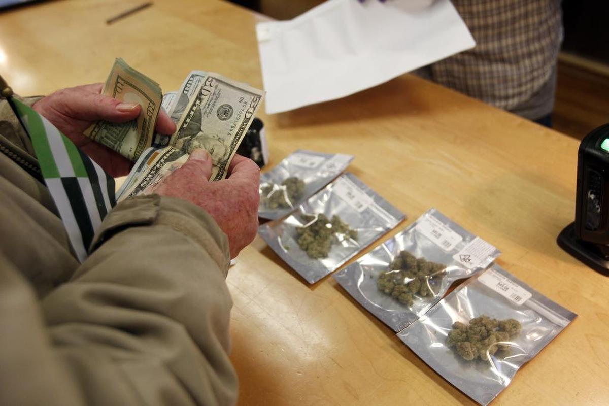 In this Jan. 1, 2018 photo, a customer purchases marijuana at Harborside marijuana dispensary in Oakland, Calif. Attorney General Jeff Sessions is rescinding a policy that had let legalized marijuana flourish without federal intervention across the country.