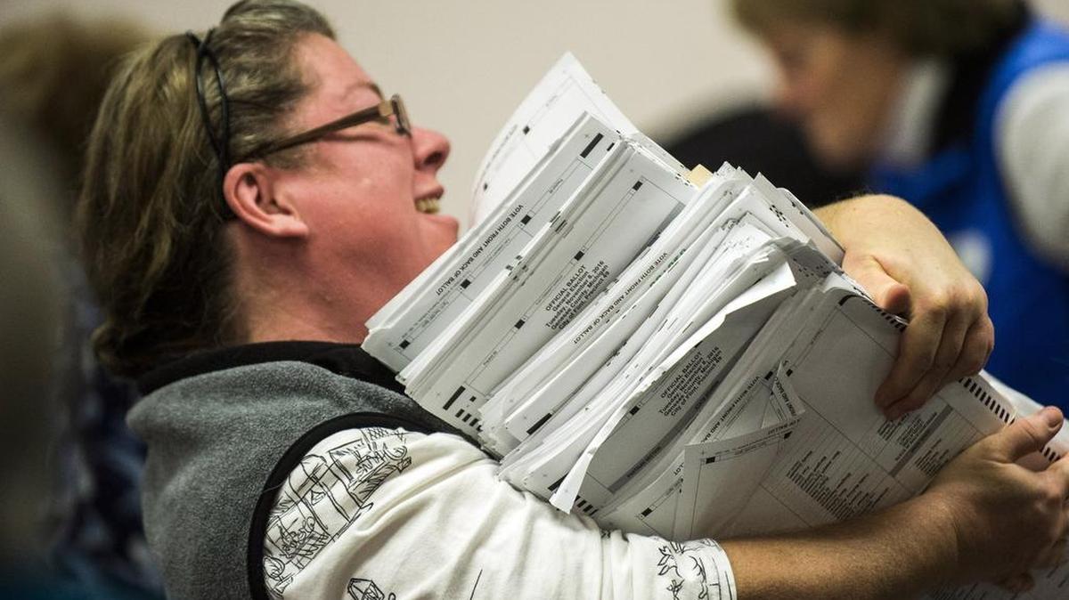 Election workers recount votes on Flint ballots, as they begin the process of a statewide recount on Wednesday, Dec. 7, 2016 at Genesee County Administration Building in Flint, Mich. A federal judge has ended Michigan's presidential recount after the state's second-highest court said the Green Party nominee was ineligible to seek a second look at millions of ballots.