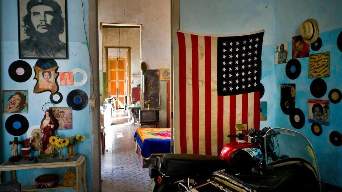 An image of revolutionary hero Ernesto "Che" Guevara hangs across the doorway from a Stars and Stripes in Havana, Cuba, Tuesday, March 15, 2016. Five days ahead of the first presidential trip to Havana in nearly 90 years, the U.S. eliminated a ban on Cuban access to the international banking system.