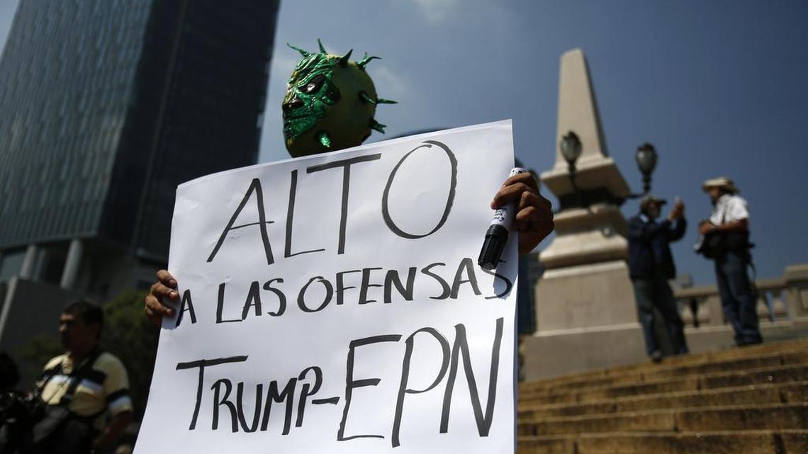 Diego Garcia wears a Mexican wrestling mask and holds a sign reading in Spanish; “Stop the offenses of Trump and EPN,” referring to Mexican President Enrique Peña Nieto, as he protests Donald Trump’s meeting with the president Wednesday in Mexico City.
