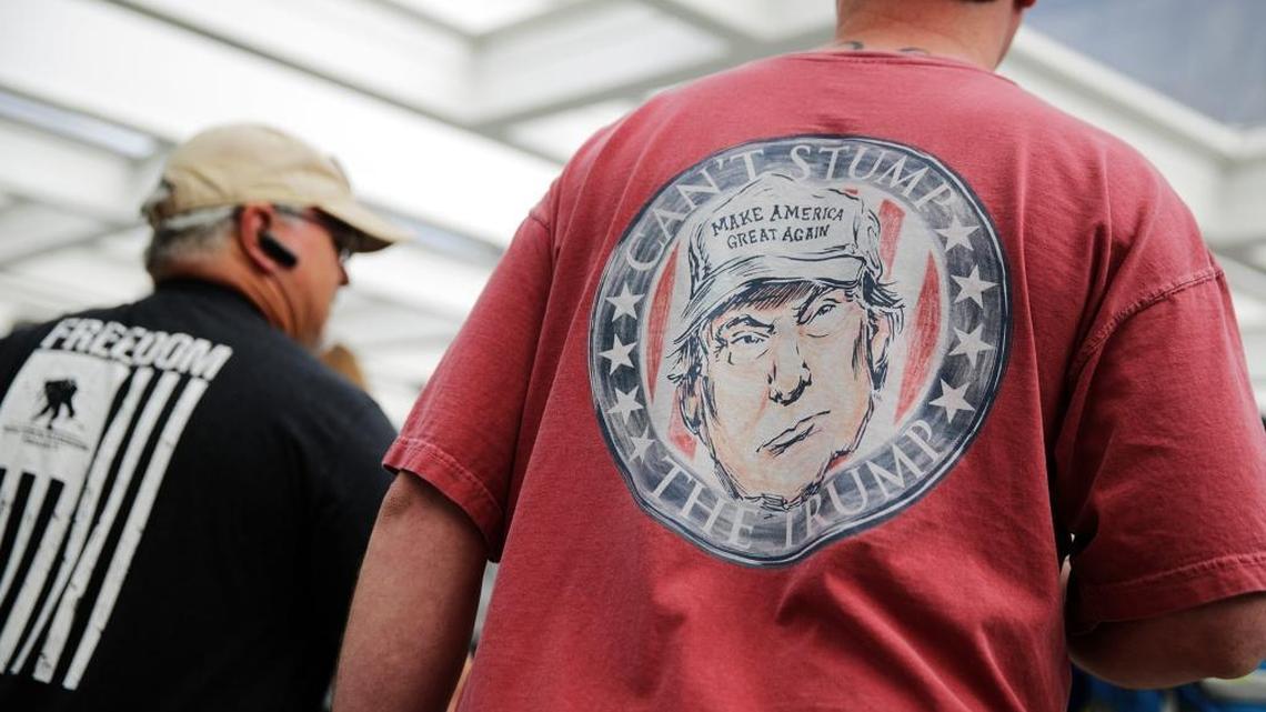 A caricature of President Donald Trump decorates the shirt of a convention-goer as he walks into the NRA annual convention in Atlanta.