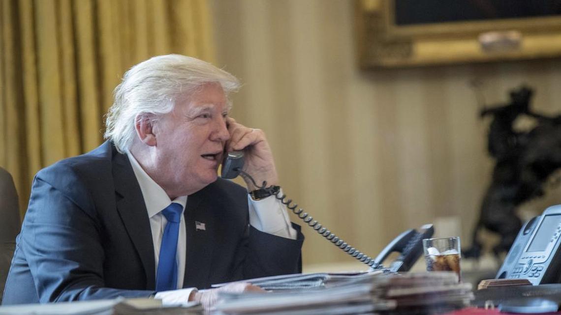 President Donald Trump speaks on the phone with Russian President Vladimir Putin, Saturday, Jan. 28, 2017, in the Oval Office at the White House in Washington.