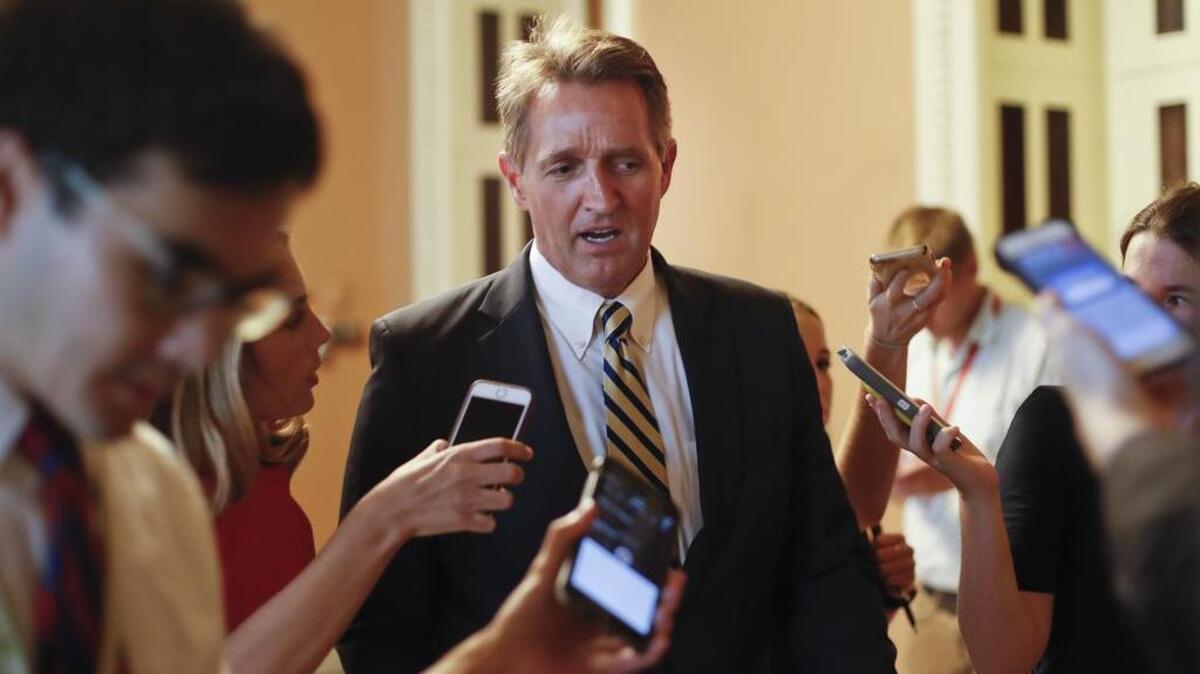 Sen. Jeff Flake, R-Ariz. speaks to members of the media as he walks to a meeting on Capitol Hill in Washington.