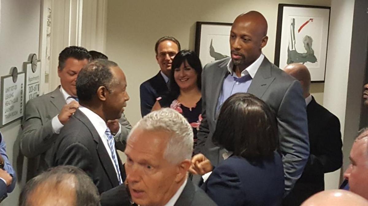 Housing and Urban Development Secretary Ben Carson emerges from a stuck elevator at Courtside Morning Apartments on Wednesday in Miami as former NBA player Alonzo Mourning waits anxiously.