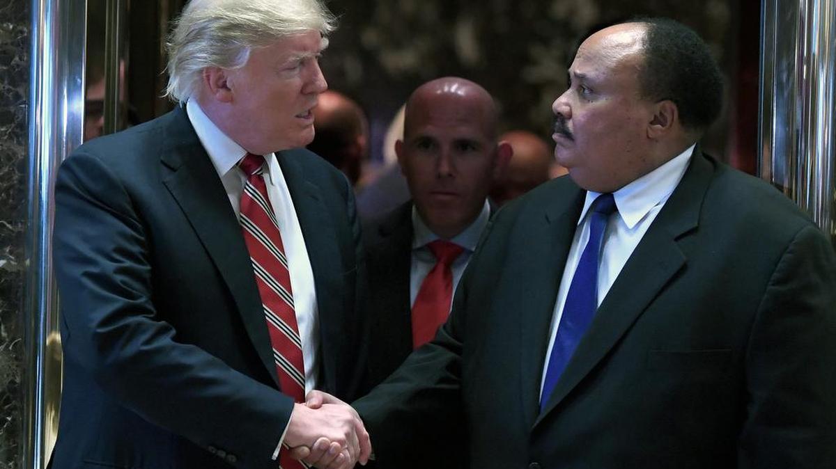 President-elect Donald J. Trump shakes hands with Martin Luther King III as they exit the elevators in the lobby of the Trump Tower on Monday, Jan. 16, 2017, in New York.