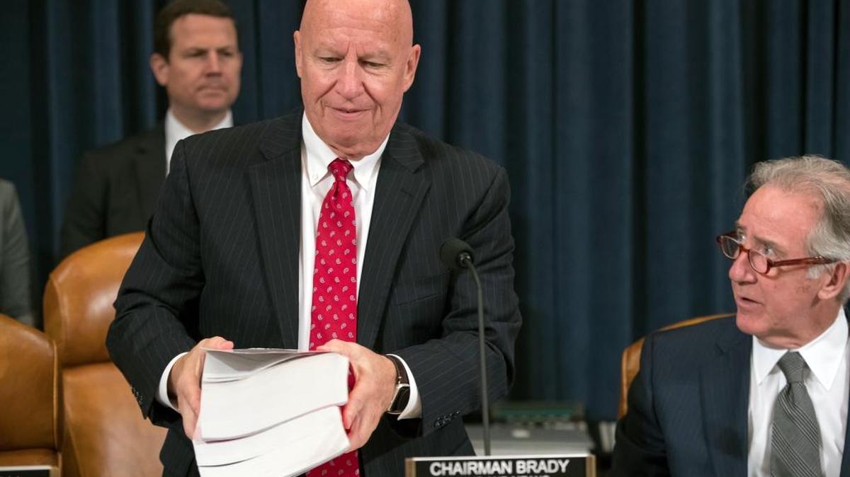 House Ways and Means Committee Chairman Kevin Brady, R-Texas, joined by Rep. Richard Neal, D-Mass., right, the ranking member, carries copies of the IRS Code as his panel begins the markup process of the GOP's far-reaching tax overhaul Monday.