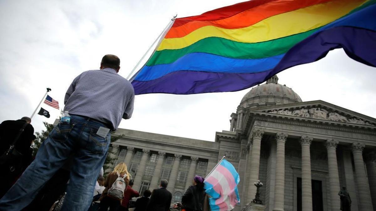In this March 31, 2016, photo, gay-rights supporters rally outside the Missouri Capitol in Jefferson City to protest Senate Joint Resolution 39, which would ask voters to amend Missouri’s Constitution to protect certain individuals and businesses who cite religious beliefs to refuse service to same-sex couples. Businesses from around Missouri on Tuesday, April 12, 2016, announced the formation of a coalition designed to stop the amendment, which is making its way through the legislature.