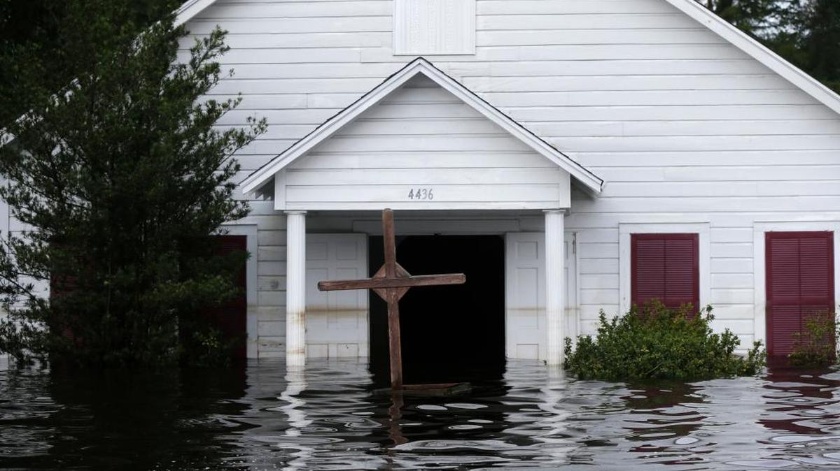 A crucifix stands in front of a flooded church in the aftermath of Tropical Storm Harvey in Vidor, Texas.