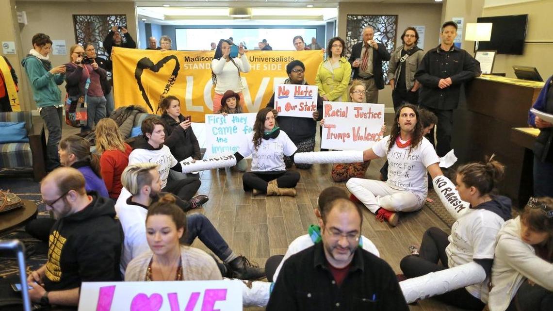 Demonstrators stage a sit-in in the lobby of the Holiday Inn Express in Janesville, Wis., on Monday, protesting a planned campaign stop by Republican presidential front-runner Donald Trump.