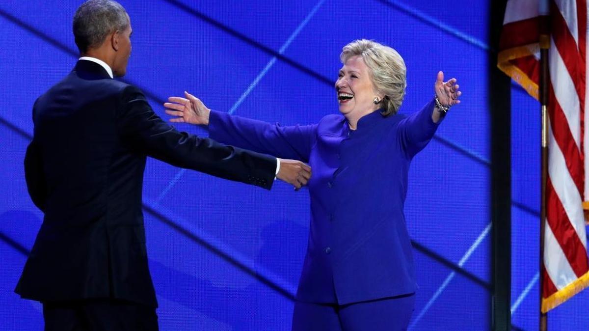 Democratic presidential nominee Hillary Clinton reaches for President Barack Obama as she steps on stage after President Obama's speech during the third day of the Democratic National Convention in Philadelphia , Wednesday, July 27, 2016.