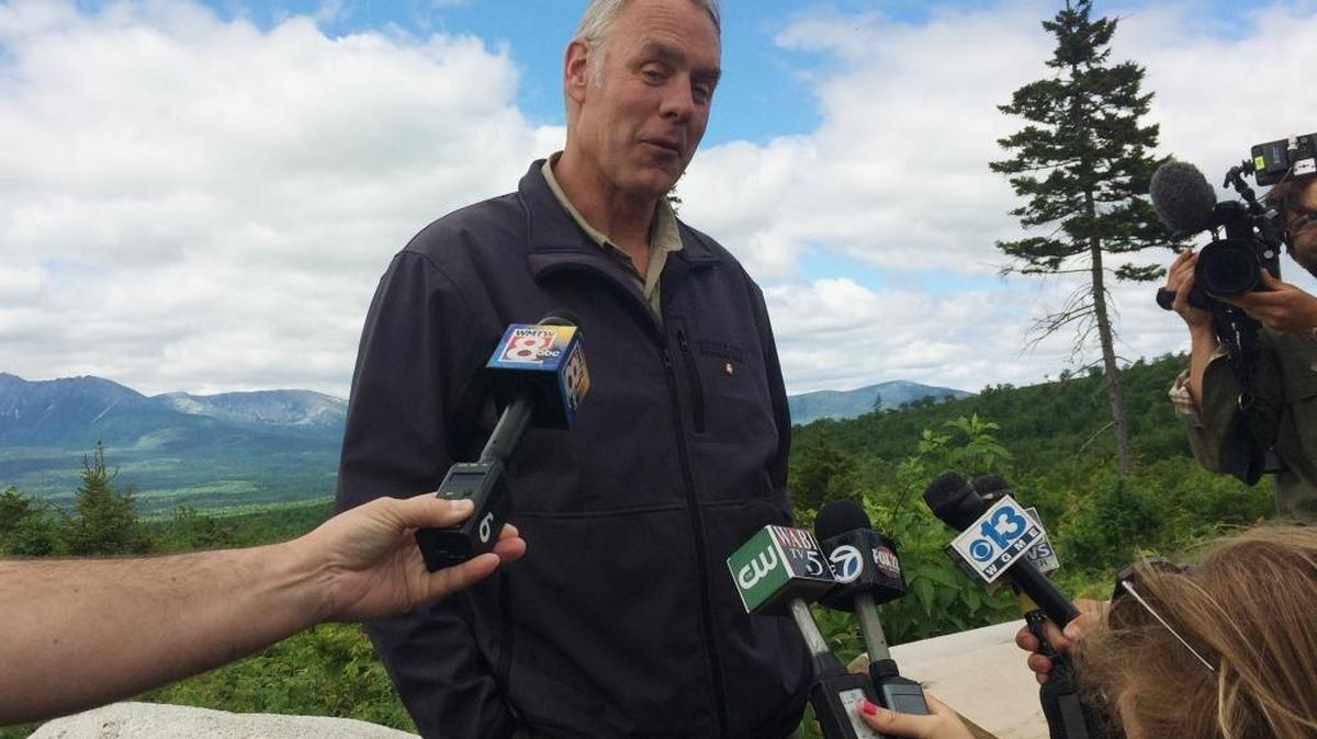 Interior Secretary Ryan Zinke talks with reporters with part of Mount Katahdin in the background at the Katahdin Woods And Waters National Monument near Staceyville, Maine, June 14, 2017.