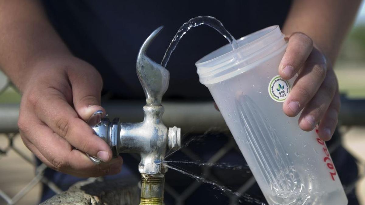 A 16-year-old fills his water BPA-free container during spring football training in May of 2012.