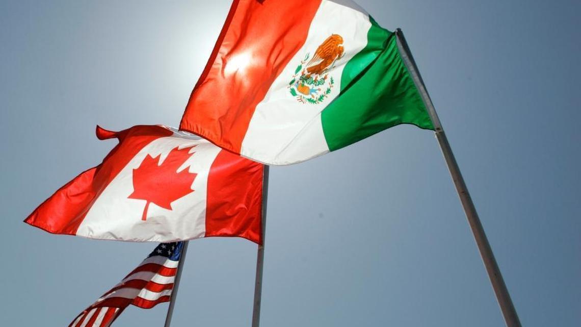 National flags representing the United States, Canada, and Mexico fly in the breeze in New Orleans where leaders of the North American Free Trade Agreement met.