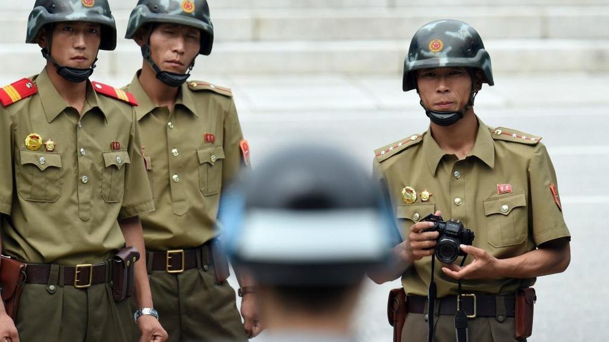 North Korean soldiers gaze across at a South Korean soldier amid a ceremony marking the 64th anniversary of the signing of the Korean War Armistice Agreement at the Panmunjom truce village in the Demilitarized Zone (DMZ) on July 27, 2017. South Korea has proposed talks with North Korea at Panmunjon, which could be the first steps toward negotiations involving the United States.