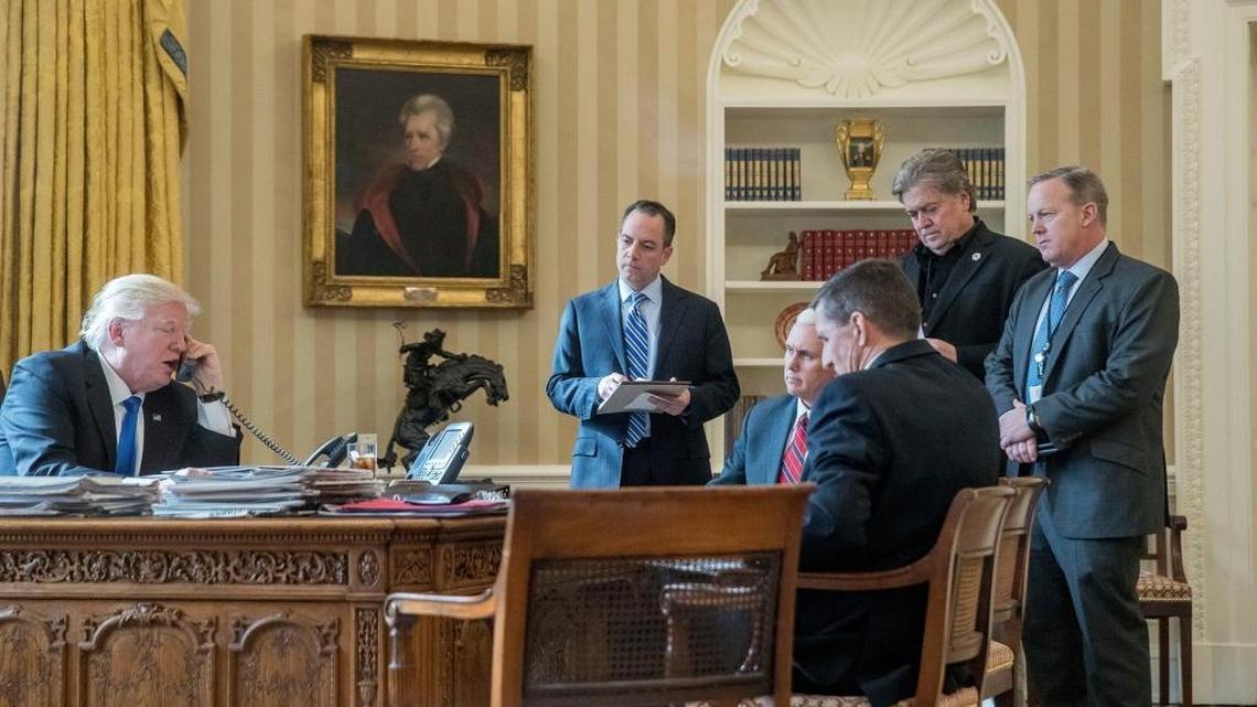 White House senior adviser Steve Bannon, second from right, in black suit, listens as President Donald Trump speaks on the phone with Russian President Vladimir Putin, Saturday, Jan. 28, 2017, in the Oval Office at the White House. Trump also is accompanied by, from second from left, Chief of Staff Reince Priebus, Vice President Mike Pence, National Security Adviser Michael Flynn and White House Press Secretary Sean Spicer.