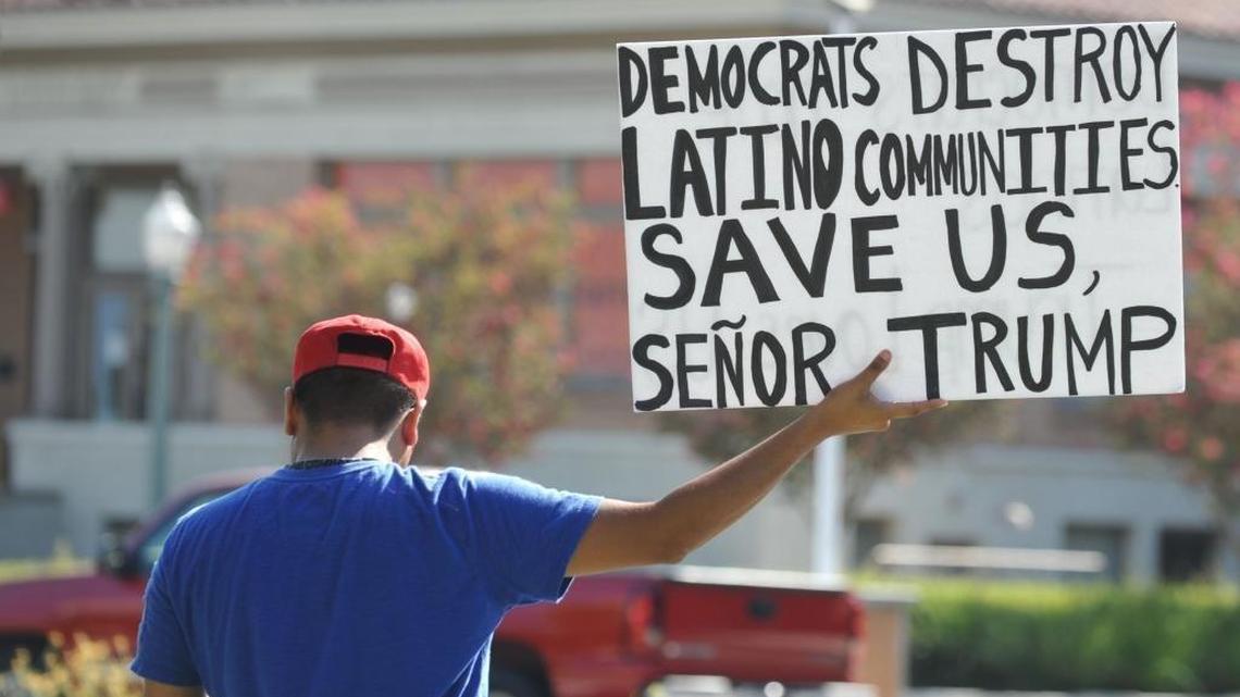 A supporter of Republican presidential nominee Donald Trump holds up a sign for passing cars at a "Latinos For Trump" rally at Anaheim City Hall Sunday, Aug. 28, 2016.