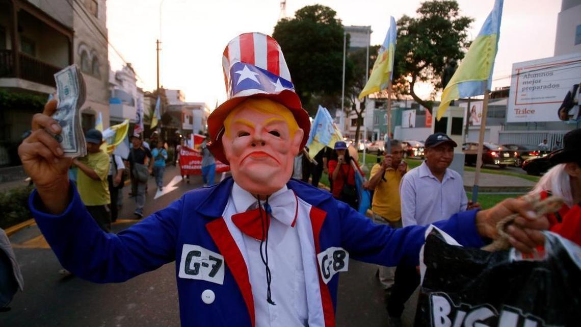 A man wearing a mask that depicts U.S. President Donald Trump participates in a protest against the Summit of the Americas, in Lima, Peru, Thursday, April 12, 2018. Trump who had planned to attend the 8th Summit of the Americas in Lima canceled his plans, choosing to stay in Washington to manage the U.S. response to an apparent chemical weapons attack on civilians in Syria. The international summit begins Friday. (AP Photo/Karel Navarro)