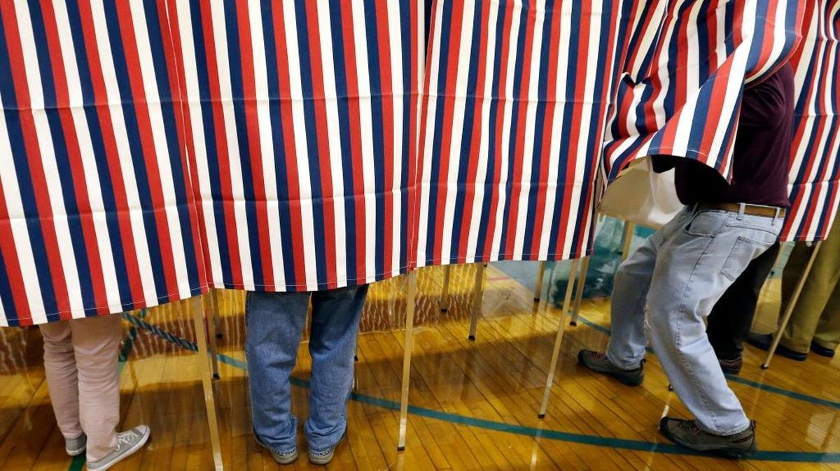 In this Election Day file photo, a voter enters a booth at a polling place in Exeter, N.H. President-elect Donald Trump tweeted himself into a controversy over voter fraud Sunday, claiming that it had occurred in New Hampshire, Virginia and California. On Monday the New Hampshire Attorney General's Office said it didn't have evidence to back up that claim.