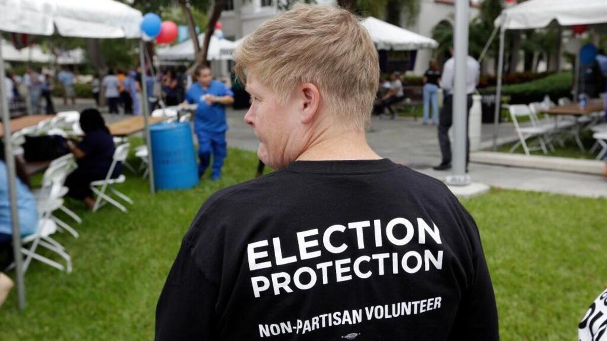 Lisa Hubbard, a volunteer with the non-partisan Election Protection Coalition, attends an early voting celebration outside of Jackson Memorial Hospital, on the first day of early voting in Miami-Dade County for the general election, Monday, Oct. 24, 2016, in Miami. The event was organized by local unions and immigrant groups to encourage people to vote during the two week early voting period. (AP Photo/Lynne Sladky)