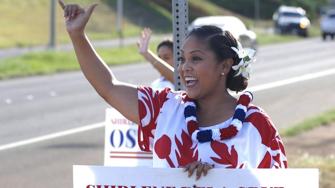 Shirlene Ostrov, Republican candidate for Congress, waves to drivers at a highway intersection in Waipahu, Hawaii, Nov. 2, 2016.