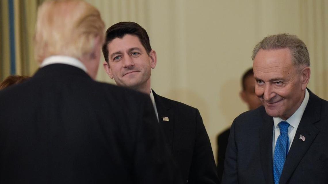 President Donald Trump talks with House Speaker Paul Ryan, R-Wis., center, and Senate Minority Leader Chuck Schumer, D-N.Y., during a reception for House and Senate leaders in the the State Dining Room of the White House on Monday, Jan. 23, 2017.