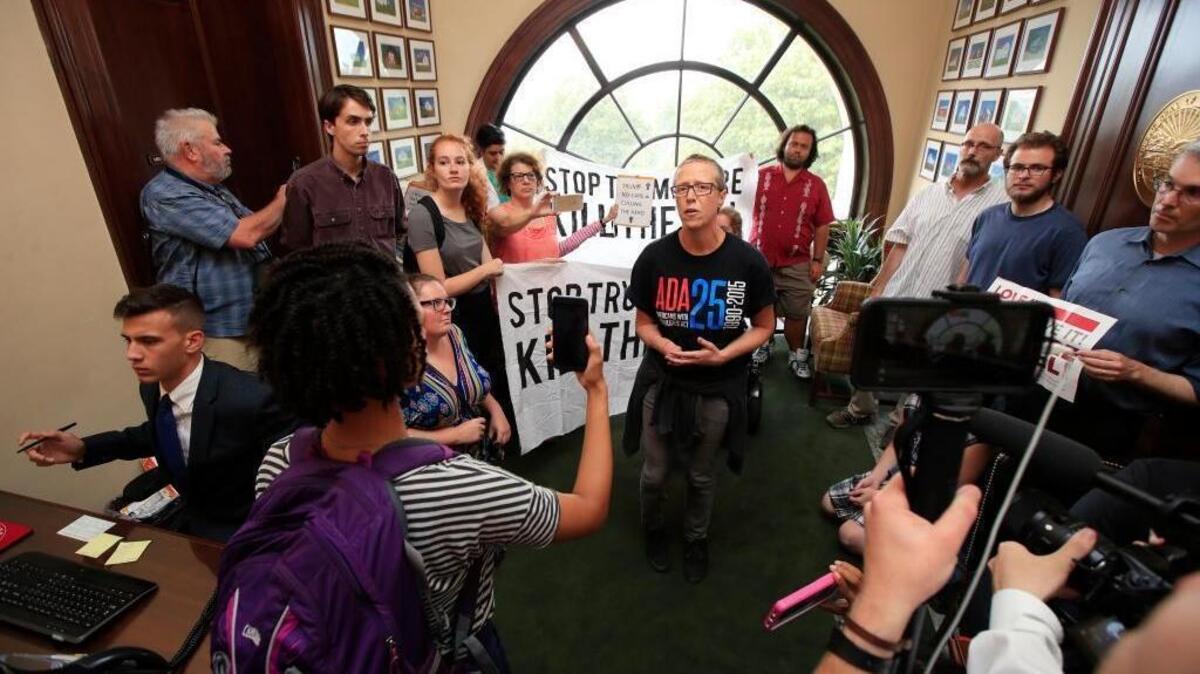 Protesters against the Republican health care bill are gathered inside the office of Sen. Rob Portman, R-Ohio, on Capitol Hill in Washington, Monday.