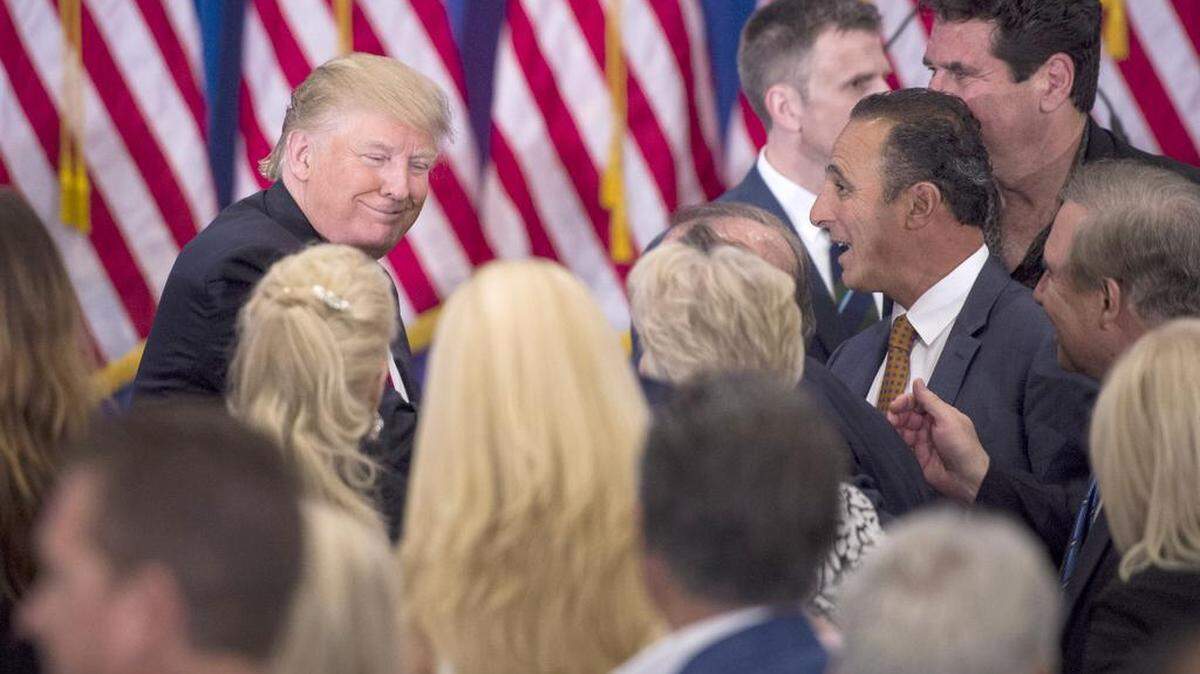 Donald Trump greets supporters as he leaves his Tuesday night news conference at Trump National Golf Club in Jupiter, Fla.