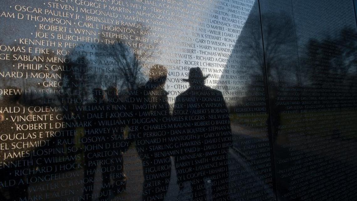 A Vietnam Veteran is reflected in the Vietnam War Memorial Wall before a ceremony to mark the 50th anniversary of the Vietnam War on March 29.